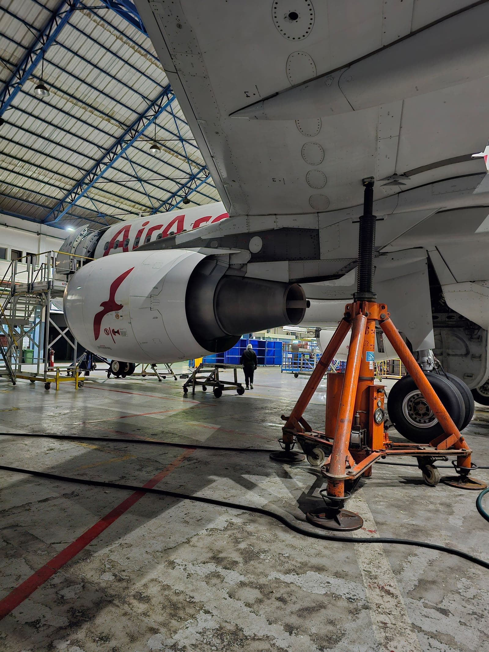 Jet engine open for maintenance inside a hangar